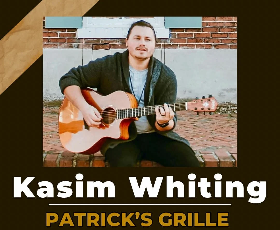 kasim Whiting local musician Kasim Whiting plays acoustic guitar on brick steps with a brick background