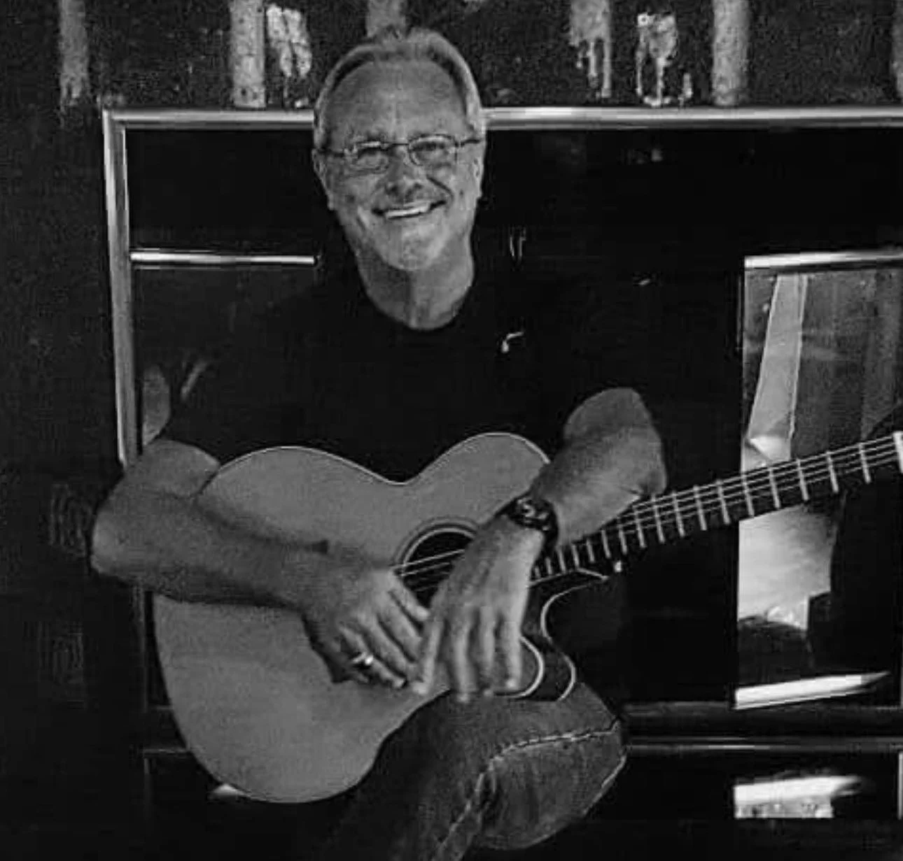 Denny Follis – Local Musician 2 Denny Follis, musician; sits and smiles with his acoustic guitar